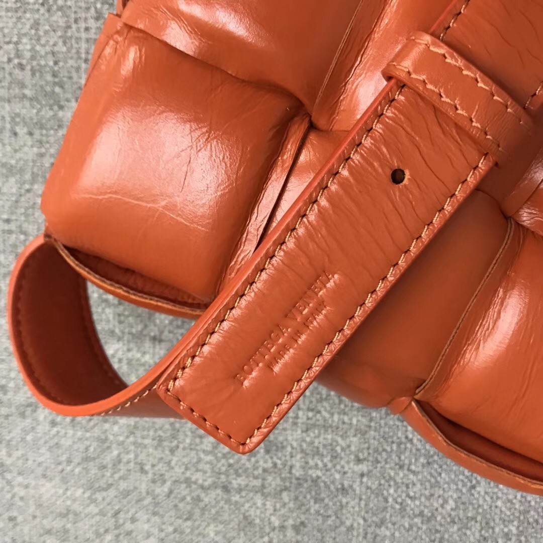 bo*te*ga Ve*ne*ta padded cassette bag in orange calfskin