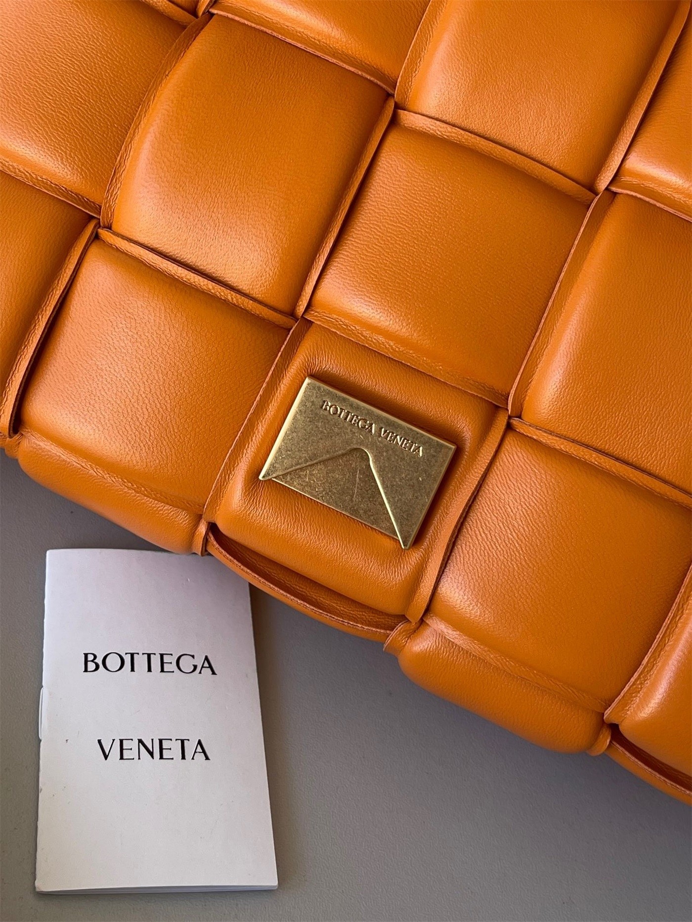 bo*te*ga Ve*ne*ta padded cassette bag in orange lambskin